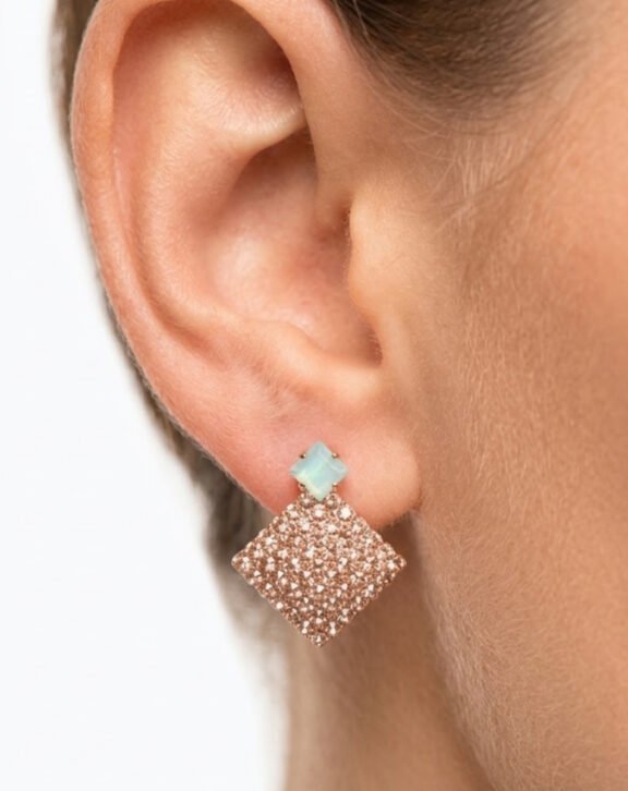Add a soft sparkle to your look with this Opal Stone Rose Glitter Square Drop Earring. Featuring a delicate opal stone top paired with a shimmering rose-tone glitter square drop, this piece blends elegance with everyday charm. Features: Rose gold tone finish Opal-style stone stud on top Lightweight square glitter drop Comfortable for all-day wear Why You Should Buy: These earrings bring a subtle sparkle without being too heavy or loud, making them perfect for both casual outings and evening looks. Perfect For: Everyday wear Casual get-togethers Gifting