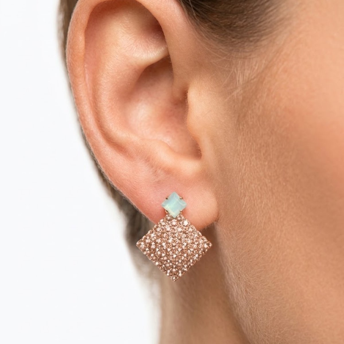 Add a soft sparkle to your look with this Opal Stone Rose Glitter Square Drop Earring. Featuring a delicate opal stone top paired with a shimmering rose-tone glitter square drop, this piece blends elegance with everyday charm. Features: Rose gold tone finish Opal-style stone stud on top Lightweight square glitter drop Comfortable for all-day wear Why You Should Buy: These earrings bring a subtle sparkle without being too heavy or loud, making them perfect for both casual outings and evening looks. Perfect For: Everyday wear Casual get-togethers Gifting