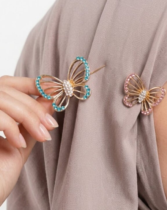 This Rhinestone Butterfly Hijab Pin Set includes two beautifully detailed butterfly pins in blue and pink tones, adding a delicate charm to your hijab or scarf styling Features: Gold-tone metal frame Rhinestone-studded wings Set of 2 (large + small) Secure pin backing Why You Should Buy: A cute and practical accessory that secures your hijab while adding a pretty sparkle — great value with two pins in one set. Perfect For: Everyday hijab styling Gifting Layered pin looks