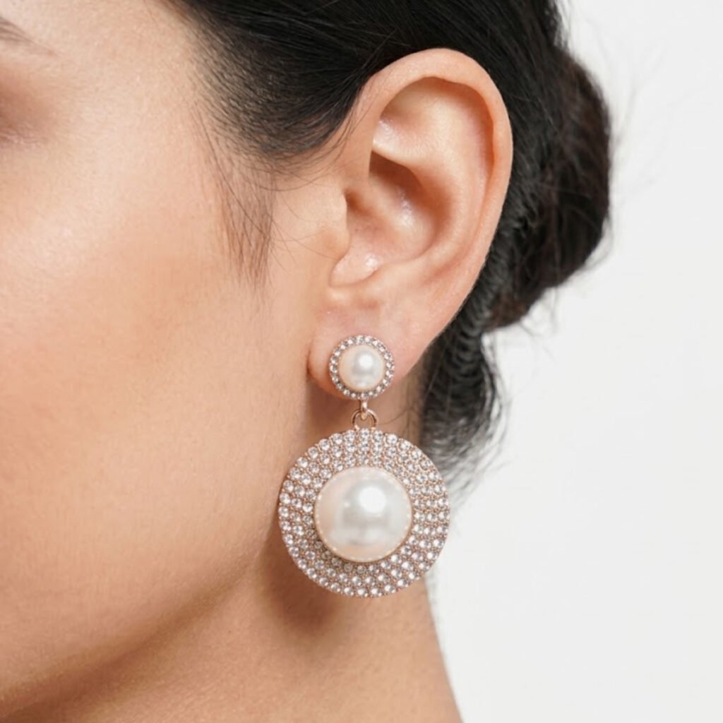 This Pearl & Crystal Pave Drop Earring features a layered design with faux pearl centers surrounded by sparkling crystal pave, creating a rich, elegant look. Features: Rose gold tone finish Double-tier round design Faux pearl centerpieces Fully crystal pave surround Why You Should Buy: The layered pearl-and-crystal design makes this a standout choice for weddings and formal events. Perfect For: Weddings and formal events Bridal styling Gifting