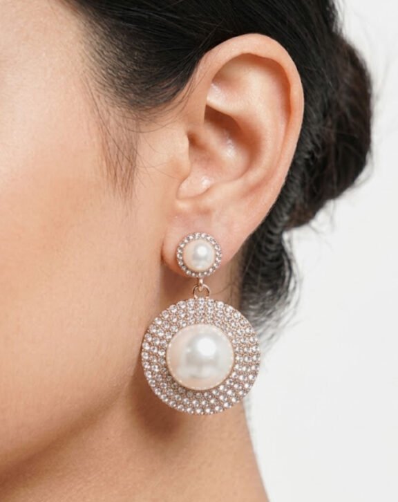 This Pearl & Crystal Pave Drop Earring features a layered design with faux pearl centers surrounded by sparkling crystal pave, creating a rich, elegant look. Features: Rose gold tone finish Double-tier round design Faux pearl centerpieces Fully crystal pave surround Why You Should Buy: The layered pearl-and-crystal design makes this a standout choice for weddings and formal events. Perfect For: Weddings and formal events Bridal styling Gifting