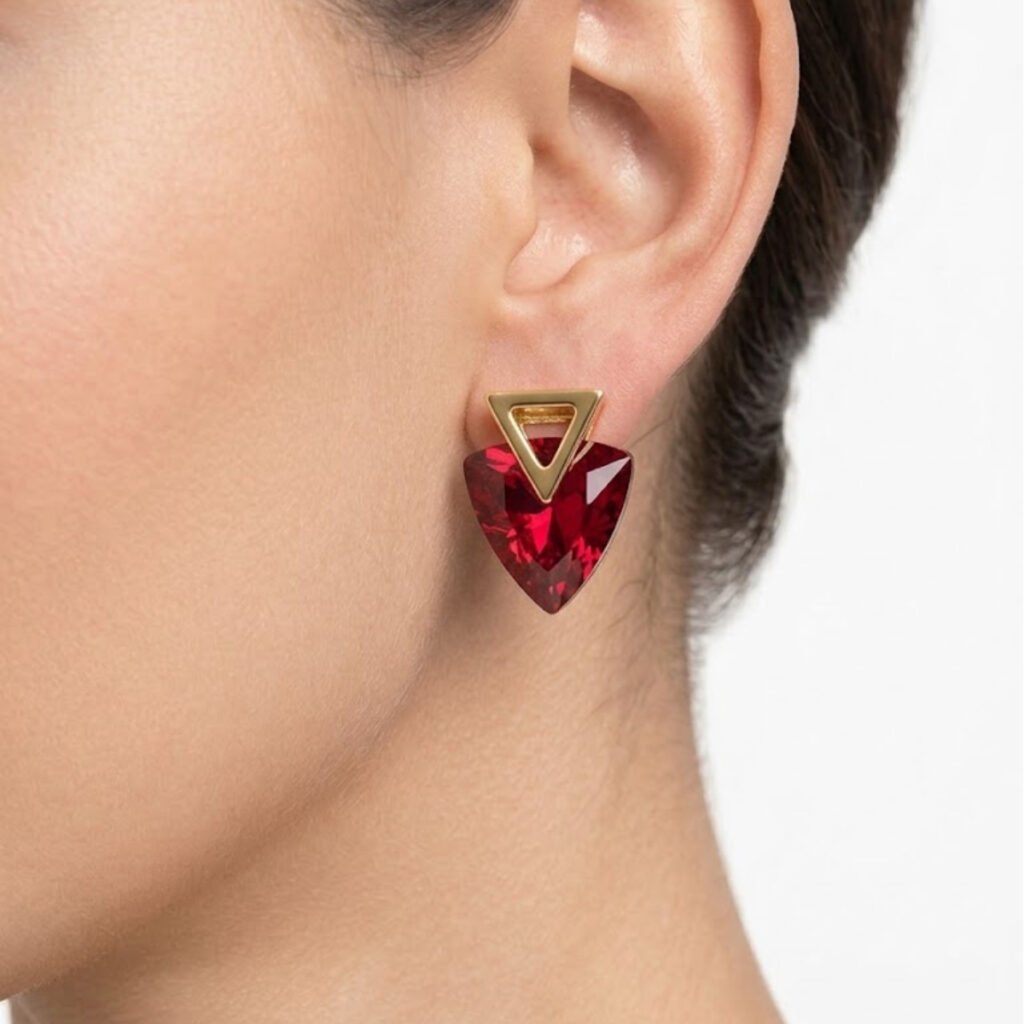 This Red Crystal Triangle Drop Earring features a bold faceted red crystal stone paired with a sleek gold triangle stud for a striking, eye-catching look. Features: Gold tone hardware Deep red faceted crystal Geometric triangle silhouette Statement-making design Why You Should Buy: The rich red color makes this a bold choice for festive occasions and statement styling. Perfect For: Festive occasions Evening wear Gifting